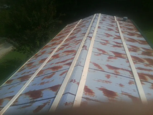 Rusted metal roof panels with new wood purlins before replacement — Storm Damage Roof Repair in Griswold by Roofing Brothers