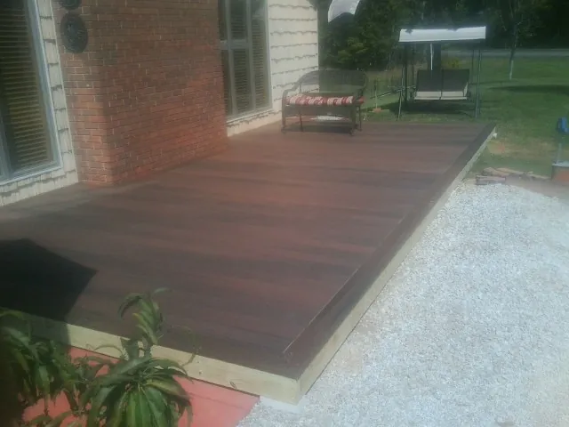 Freshly stained wood deck built against a brick home in Griswold