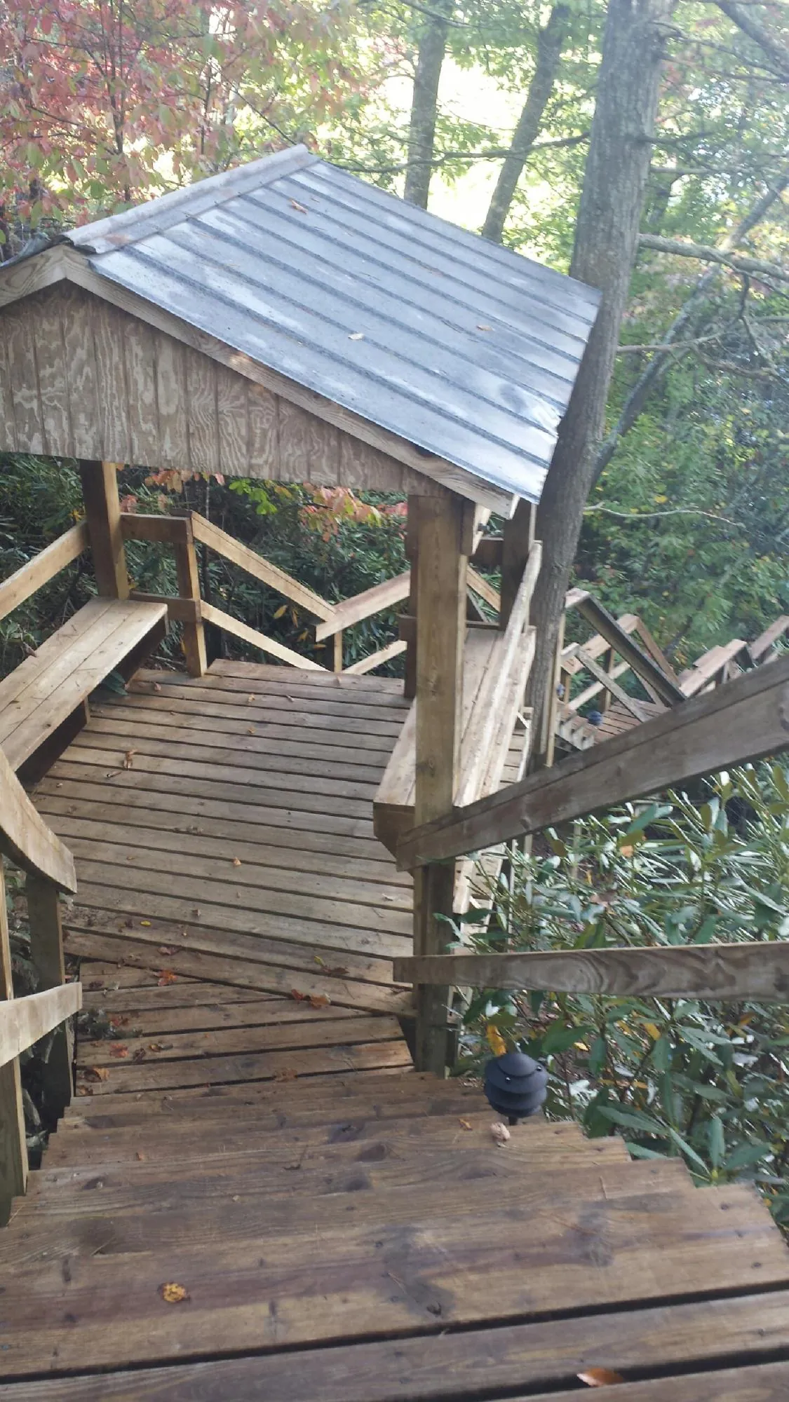 Metal roofed shelter over wooden steps on a wooded walkway — Skylight Repair & Installation work by our crew in Griswold
